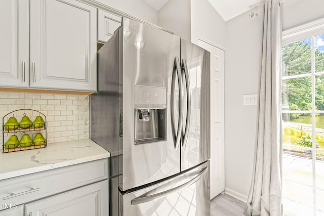 1375 Quail Cir, Creedmoor, NC 27522 - kitchen with stainless steel fridge with ice dispenser, backsplash, light stone counters, baseboards, and light wood-type flooring