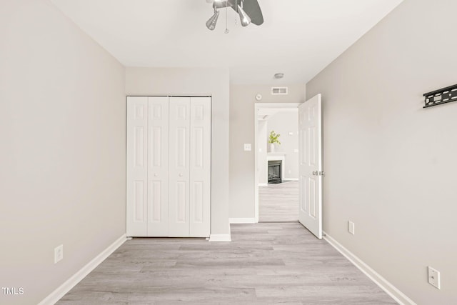 1375 Quail Cir, Creedmoor, NC 27522 - unfurnished bedroom with light wood-style flooring, baseboards, a closet, and a fireplace