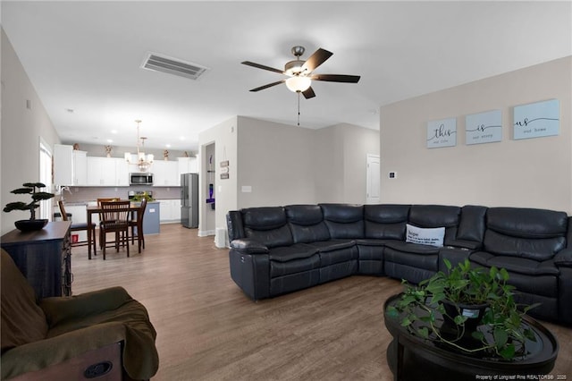 405 Shelton Beard Rd, Stedman, NC 28391 - living room featuring a ceiling fan, light wood-style floors, and a chandelier