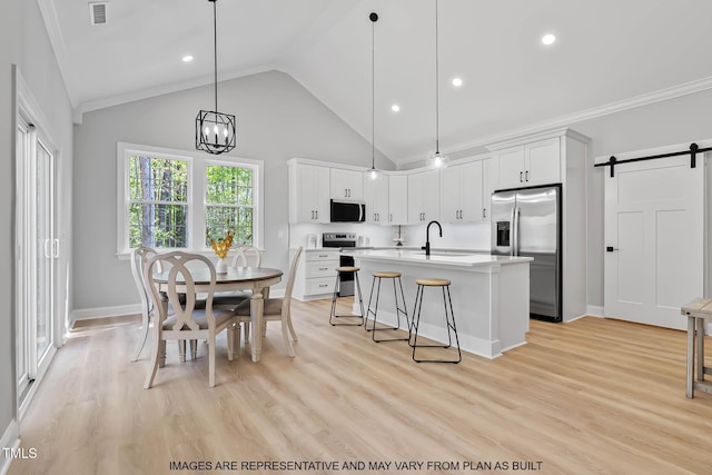 154 Buckaroo Dr, Louisburg, NC 27549 - kitchen with appliances with stainless steel finishes, a barn door, light countertops, a chandelier, and an island with sink