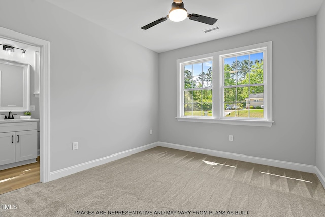 154 Buckaroo Dr, Louisburg, NC 27549 - unfurnished bedroom with a sink, light carpet, baseboards, connected bathroom, and ceiling fan
