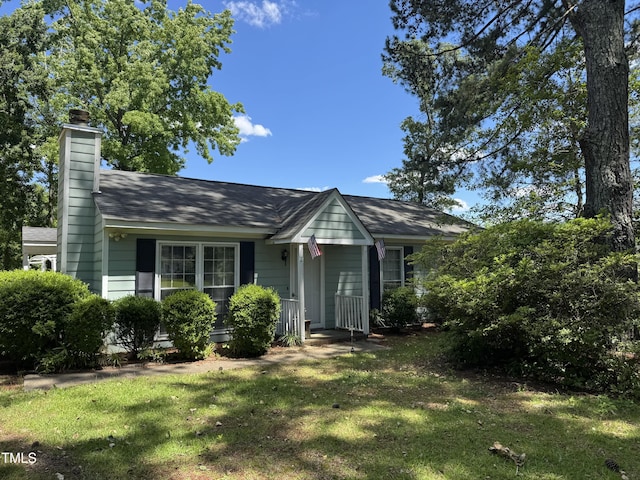 8405 Falcon Crest Cir, Angier, NC 27501 - view of front of home featuring a front yard, a chimney, and a shingled roof