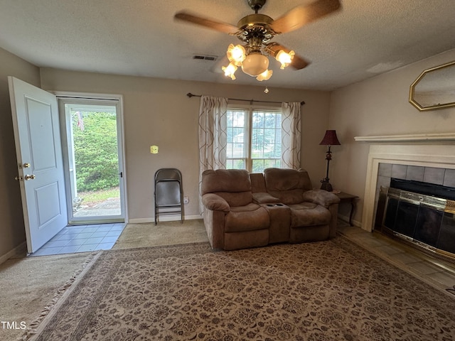 8405 Falcon Crest Cir, Angier, NC 27501 - tiled living room featuring a ceiling fan, a textured ceiling, healthy amount of natural light, and a fireplace