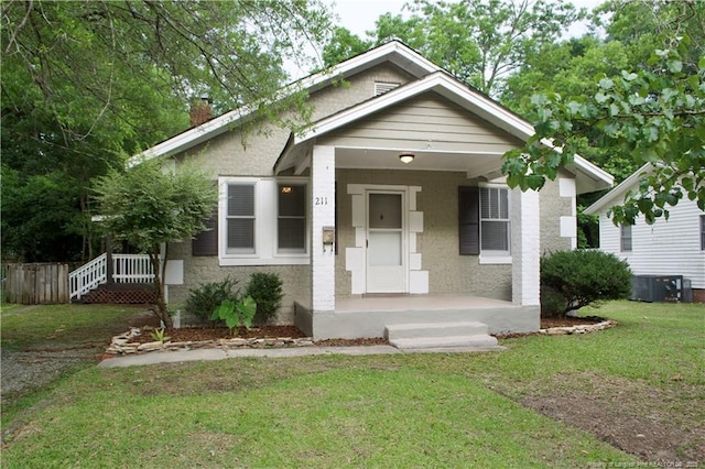 211 Sedberry St, Fayetteville, NC 28305 - bungalow featuring a front lawn, a chimney, stucco siding, and cooling unit