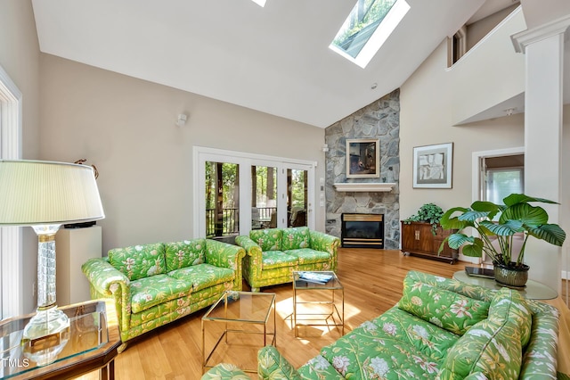 81106 Alexander, Chapel Hill, NC 27517 - living area featuring healthy amount of natural light, a stone fireplace, high vaulted ceiling, a skylight, and wood finished floors