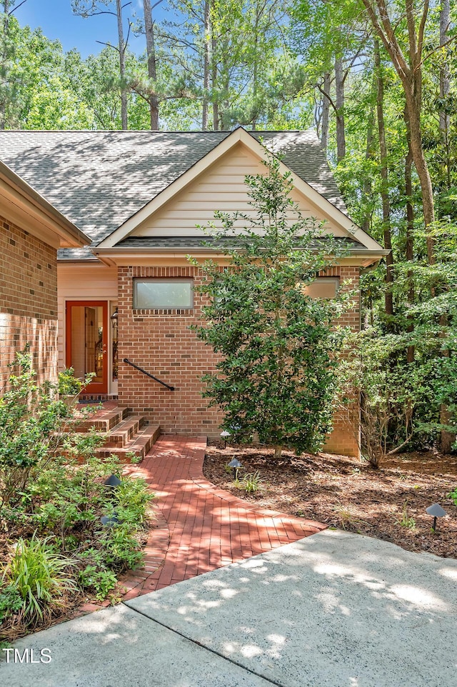 81106 Alexander, Chapel Hill, NC 27517 - view of front of property featuring brick siding, a shingled roof, and a patio