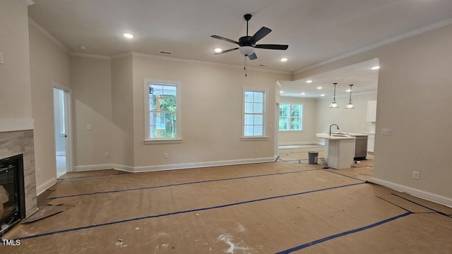 109 Drew St, Louisburg, NC 27549 - unfurnished living room featuring baseboards, a glass covered fireplace, ornamental molding, ceiling fan, and recessed lighting