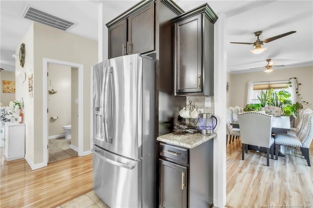 374 Boswell St, Raeford, NC 28376 - kitchen with stainless steel fridge with ice dispenser, dark brown cabinetry, ceiling fan, light wood-style flooring, and light stone countertops