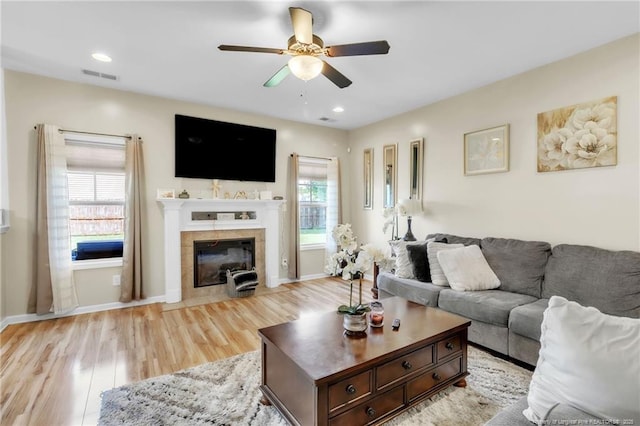 374 Boswell St, Raeford, NC 28376 - living room with a ceiling fan, light wood finished floors, a tile fireplace, baseboards, and recessed lighting