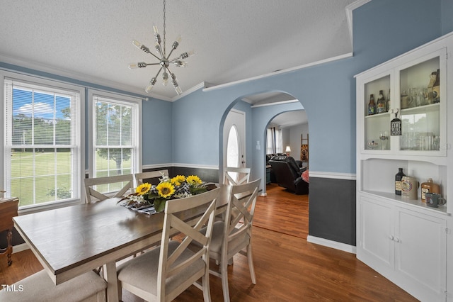 1993 Lucy Garrett Rd, Roxboro, NC 27574 - dining space with ornamental molding, a textured ceiling, dark wood-style floors, arched walkways, and a chandelier