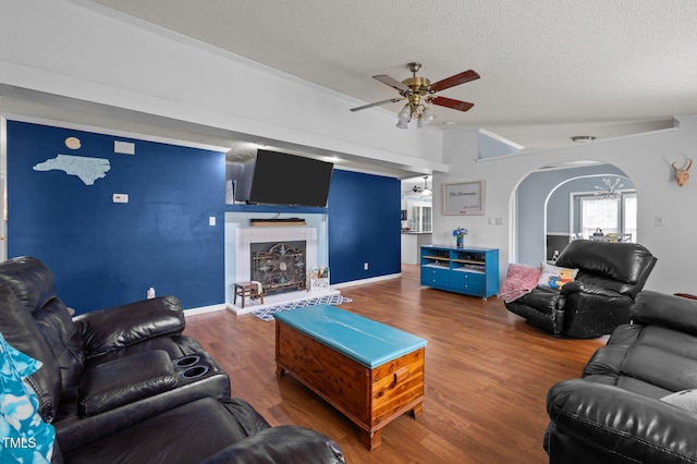 1993 Lucy Garrett Rd, Roxboro, NC 27574 - living area featuring a ceiling fan, a textured ceiling, arched walkways, a tile fireplace, and wood finished floors