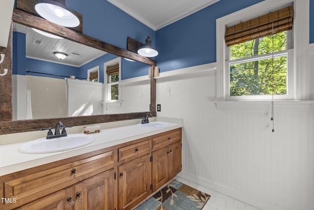 1 Gatesway Ct, Durham, NC 27707 - bathroom featuring double vanity, a shower with curtain, a wainscoted wall, and tile patterned flooring