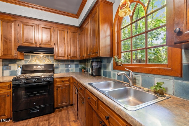 1 Gatesway Ct, Durham, NC 27707 - kitchen featuring gas stove, under cabinet range hood, ornamental molding, brown cabinets, and dark wood-style floors