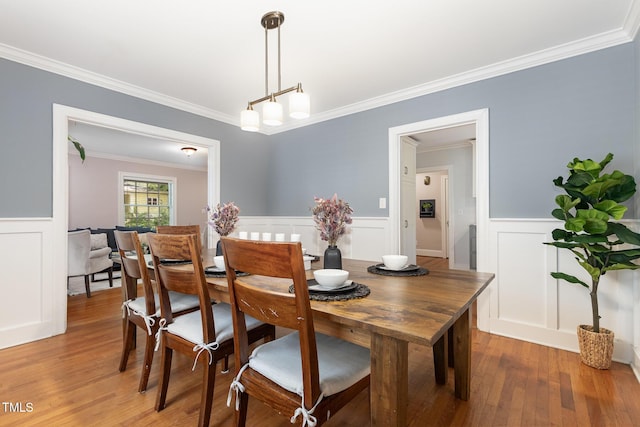 821 Onslow St, Durham, NC 27705 - dining room with a decorative wall, light wood-type flooring, crown molding, and a wainscoted wall