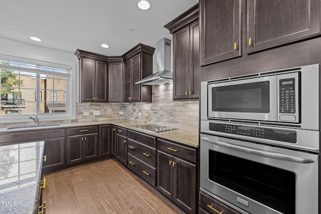 531 N Person St Unit 205, Raleigh, NC 27604 - kitchen with wall chimney range hood, stainless steel appliances, a sink, light wood-style flooring, and light stone counters