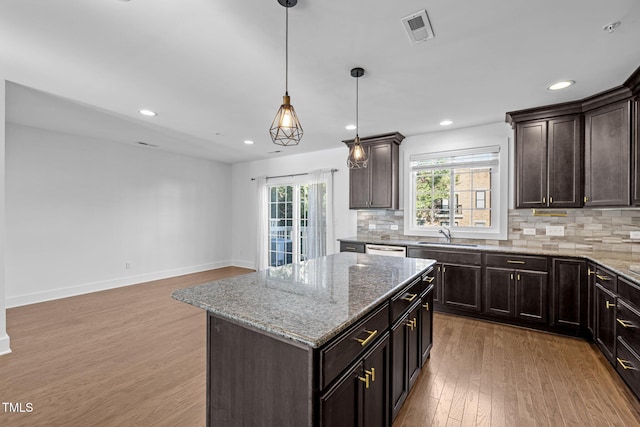 531 N Person St Unit 205, Raleigh, NC 27604 - kitchen featuring light wood-type flooring, tasteful backsplash, light stone counters, dark brown cabinetry, and recessed lighting