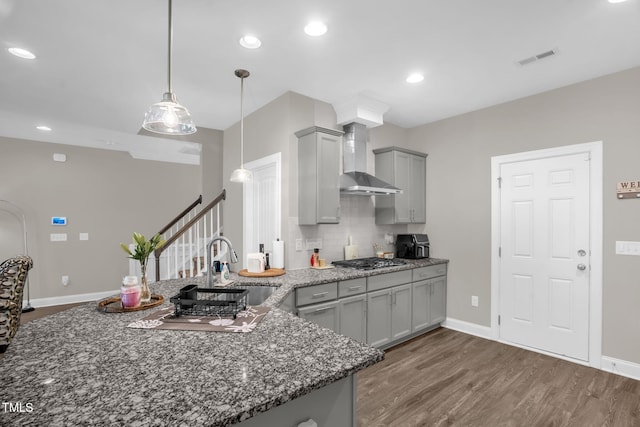 512 Barneswyck Dr, Fuquay Varina, NC 27526 - kitchen with gray cabinetry, wall chimney range hood, dark wood-type flooring, a sink, and decorative backsplash