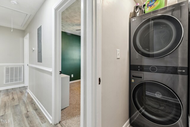 1841 Conover Dr, Fayetteville, NC 28304 - laundry area with attic access, stacked washer / drying machine, baseboards, wood finished floors, and electric panel