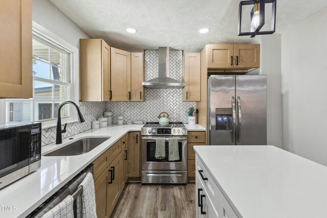 1841 Conover Dr, Fayetteville, NC 28304 - kitchen featuring appliances with stainless steel finishes, wall chimney range hood, a sink, light countertops, and dark wood-type flooring