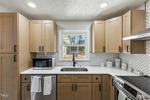 1841 Conover Dr, Fayetteville, NC 28304 - kitchen featuring appliances with stainless steel finishes, a sink, backsplash, light countertops, and wall chimney exhaust hood