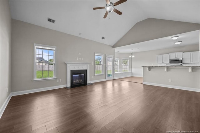 254 Blackhawk Ln, Raeford, NC 28376 - unfurnished living room with a ceiling fan, dark wood-style floors, plenty of natural light, a glass covered fireplace, and high vaulted ceiling