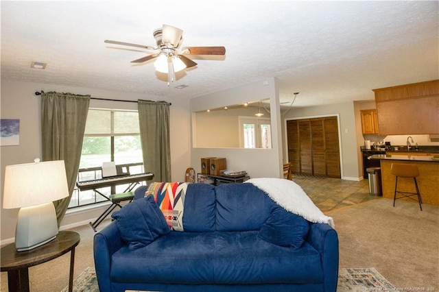 6874 Fern Creek Pl, Fayetteville, NC 28314 - living area featuring ceiling fan, a textured ceiling, light colored carpet, and baseboards