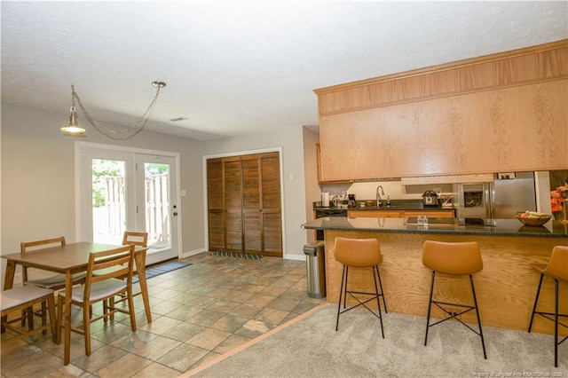 6874 Fern Creek Pl, Fayetteville, NC 28314 - kitchen featuring a sink, a kitchen bar, dark countertops, and stone tile floors