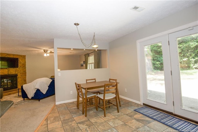 6874 Fern Creek Pl, Fayetteville, NC 28314 - dining room with light stone finish flooring, baseboards, a fireplace, and a ceiling fan