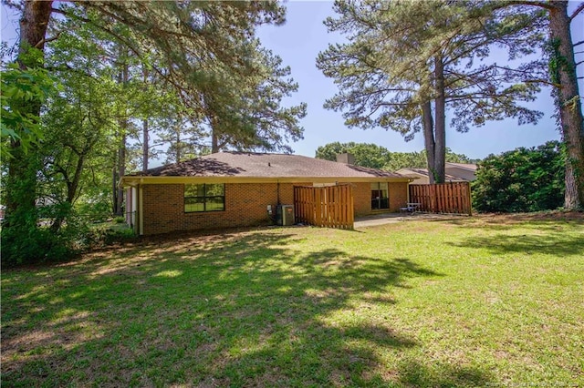6874 Fern Creek Pl, Fayetteville, NC 28314 - back of house with brick siding, a chimney, and central AC