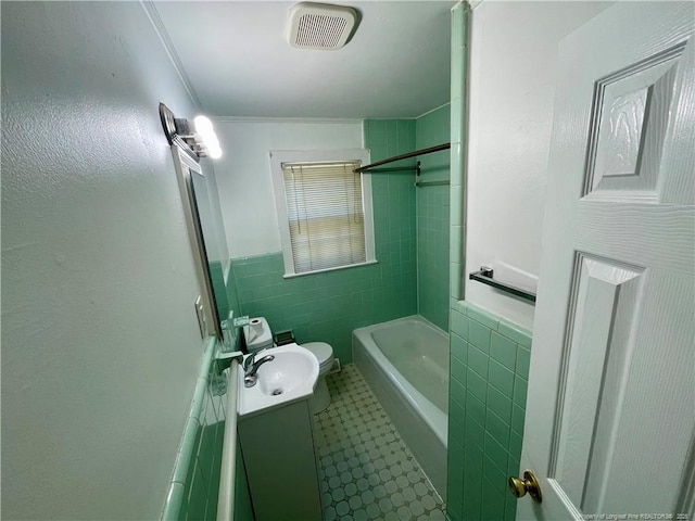 1007 Jenkins St, Lumberton, NC 28358 - full bath with tile walls, vanity, toilet, bathtub / shower combination, and wainscoting