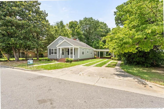 1007 Jenkins St, Lumberton, NC 28358 - view of front facade featuring concrete driveway, a front yard, and covered porch