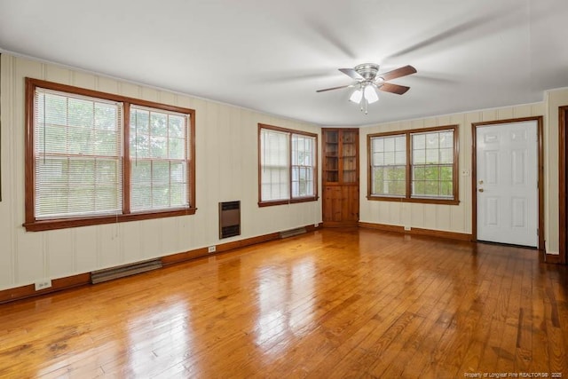 1007 Jenkins St, Lumberton, NC 28358 - unfurnished living room featuring a ceiling fan, wood-type flooring, healthy amount of natural light, and heating unit