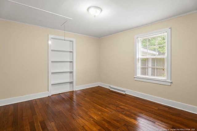 1007 Jenkins St, Lumberton, NC 28358 - empty room featuring attic access, dark wood-type flooring, ornamental molding, and built in shelves
