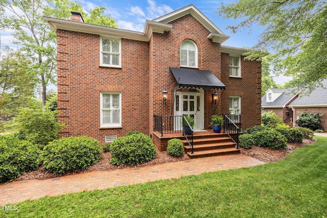 441 Fieldstone Dr, Burlington, NC 27215 - traditional home featuring a chimney, brick siding, and a front lawn
