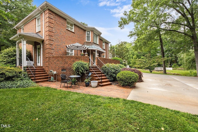 441 Fieldstone Dr, Burlington, NC 27215 - view of front of house featuring brick siding, a front yard, and a patio area