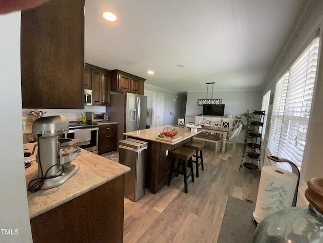 305 Briarcliff Dr, Dunn, NC 28334 - kitchen with stainless steel appliances, dark brown cabinetry, light wood-style flooring, a center island, and pendant lighting