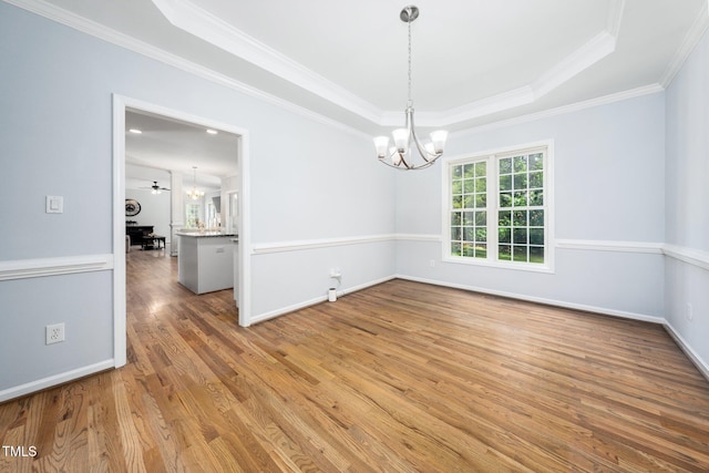 112 Sterling Ridge Way, Cary, NC 27519 - unfurnished room with a chandelier, wood finished floors, a tray ceiling, crown molding, and baseboards
