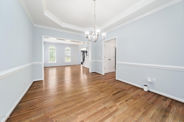 112 Sterling Ridge Way, Cary, NC 27519 - unfurnished dining area featuring a chandelier, stairs, wood finished floors, ornamental molding, and a raised ceiling