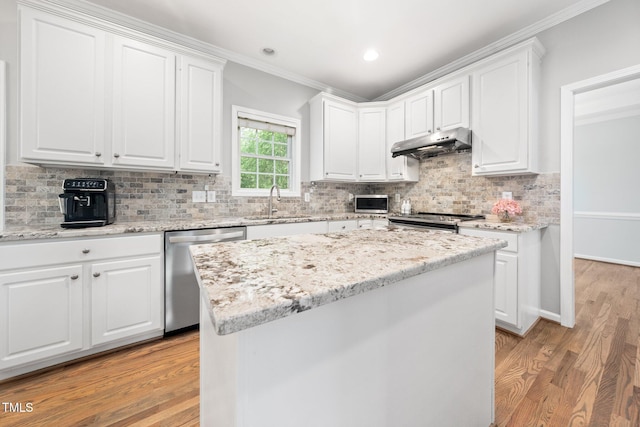 112 Sterling Ridge Way, Cary, NC 27519 - kitchen featuring appliances with stainless steel finishes, under cabinet range hood, ornamental molding, white cabinetry, and recessed lighting