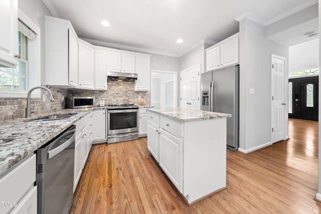 112 Sterling Ridge Way, Cary, NC 27519 - kitchen with stainless steel appliances, under cabinet range hood, a sink, light wood-type flooring, and crown molding