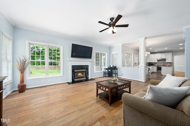 112 Sterling Ridge Way, Cary, NC 27519 - living area with a premium fireplace, ceiling fan, crown molding, ornate columns, and light wood-style flooring