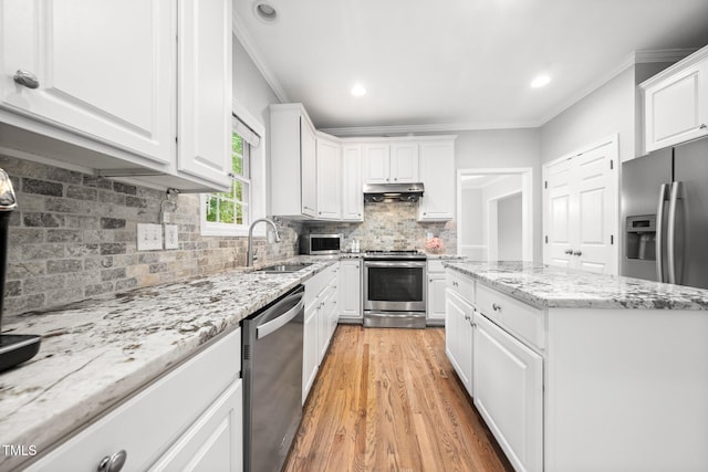 112 Sterling Ridge Way, Cary, NC 27519 - kitchen featuring stainless steel appliances, a sink, under cabinet range hood, crown molding, and white cabinetry