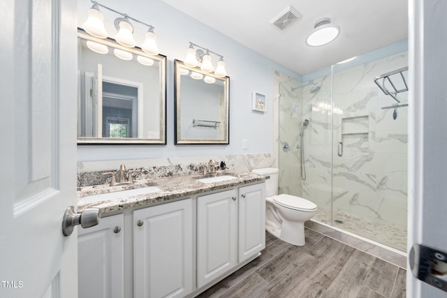 112 Sterling Ridge Way, Cary, NC 27519 - bathroom featuring a marble finish shower, double vanity, toilet, and wood finished floors