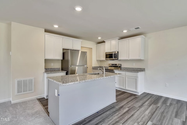 2700 Barrington Dr, Raleigh, NC 27610 - kitchen featuring stainless steel appliances, a sink, white cabinets, an island with sink, and light stone counters