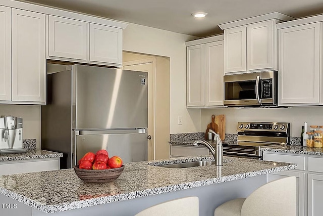 2700 Barrington Dr, Raleigh, NC 27610 - kitchen featuring appliances with stainless steel finishes, a sink, light stone counters, recessed lighting, and white cabinets