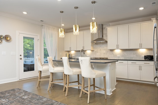 609 Ramsours Mill Dr, Holly Springs, NC 27540 - kitchen featuring wall chimney exhaust hood, dark countertops, dark wood finished floors, ornamental molding, and tasteful backsplash