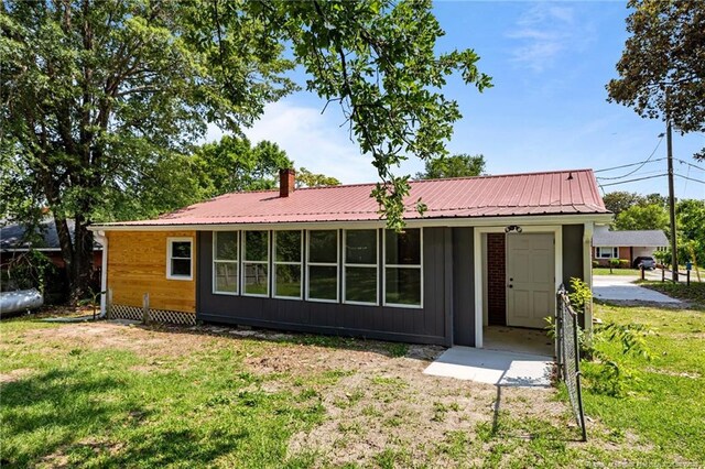 3902 Hartwell Rd, Fayetteville, NC 28304 - view of front facade with a front yard, metal roof, and a chimney