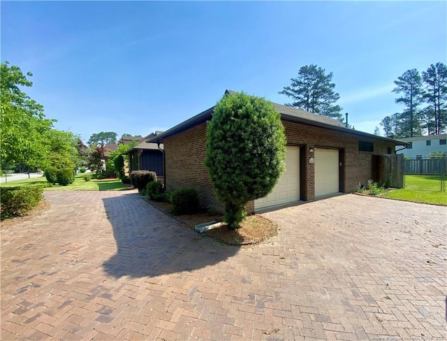 4207 Aldwych St, Lumberton, NC 28358 - view of home's exterior with brick siding, decorative driveway, and an attached garage