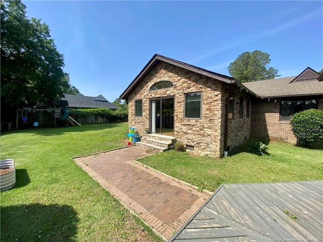 4207 Aldwych St, Lumberton, NC 28358 - back of property with a playground, stone siding, and crawl space
