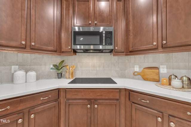 522 N Scotswood Blvd, Hillsborough, NC 27278 - kitchen featuring stainless steel microwave, light countertops, backsplash, black electric cooktop, and brown cabinets